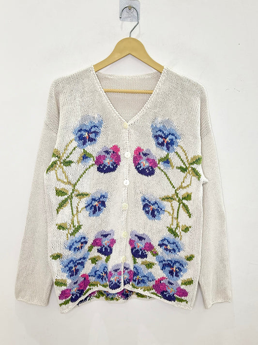 Floral patterned cardigan on a hanger against a white background
